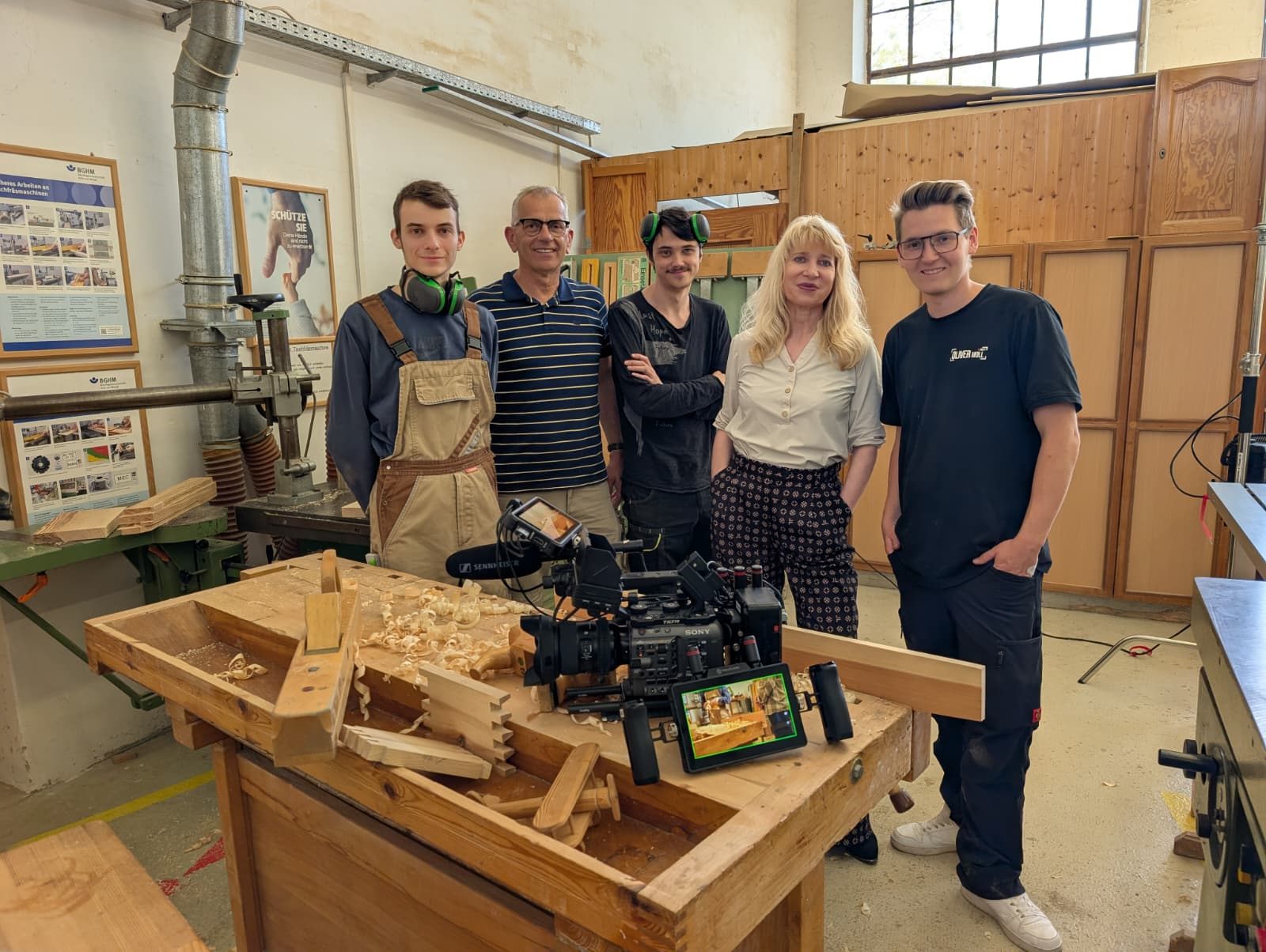 Gruppenbild am Set beim Internationalen Bund Chemnitz: Team und Oliver Moll in der Tischlerwerkstatt, vorne die Sony FX6 auf der Hobelbank